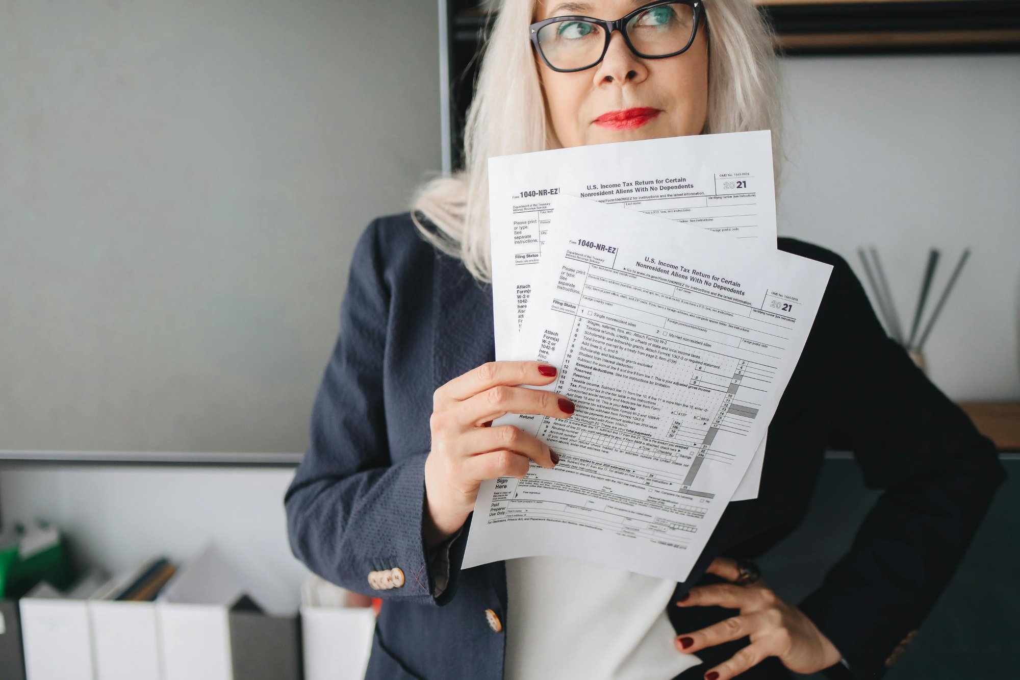 Experienced tax professional holding IRS 1040 tax return forms — Aafam Link LLC IRS audit support services