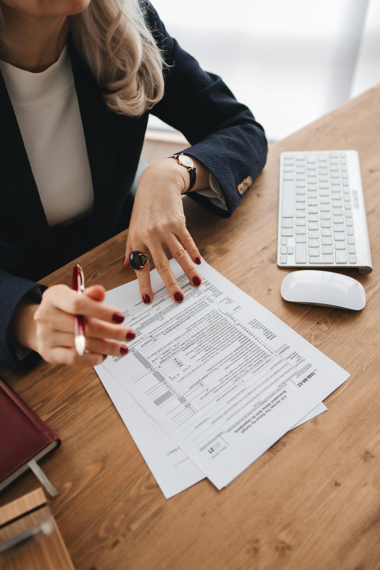 Aafam Link LLC tax professional carefully reviewing a 1040 tax return form at her desk